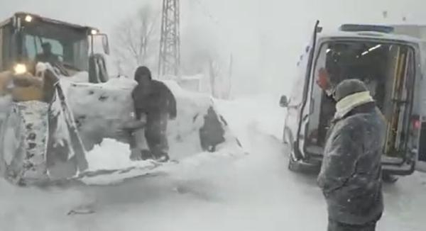 Yolu kardan kapanan mahallede rahatsızlandı, kepçeyle ambulansa taşındı